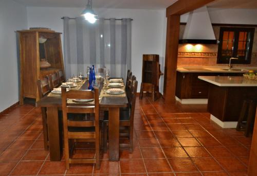 comedor con mesa y sillas y cocina en Villa Gabriela, en Tinguatón