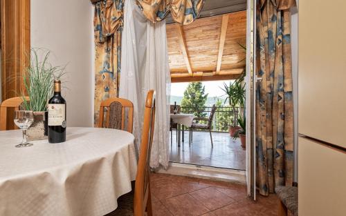 una bottiglia di vino appoggiata su un tavolo in una stanza di Tea Two Apartman a Neum