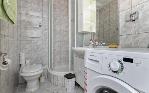 a bathroom with a toilet and a sink and a shower at Tea Two Apartman in Neum