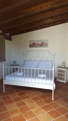 un letto bianco in una camera con soffitto in legno di Gallipoli lato sudChalet Pesco a Taviano