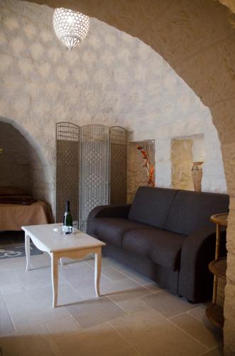 a living room with a couch and a table at Trullo Grazioso Luxury in Ceglie Messapica