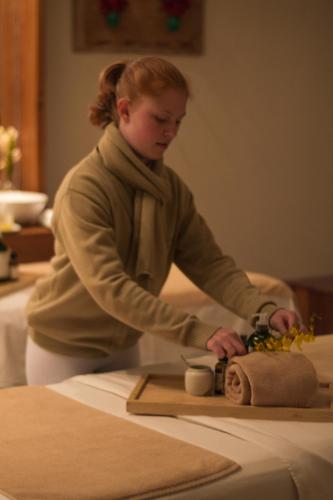 a woman standing at a table in a room at Quinta dos Pinhais Pouso e Charme in Santo Antônio do Pinhal