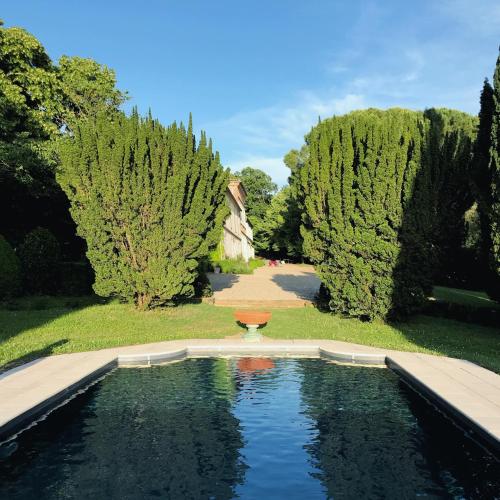 une piscine d'eau dans un jardin arboré dans l'établissement Domaine de Gailhaguet B&B, à Verfeil