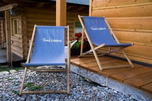 two blue chairs sitting on a porch at Domki u Huberta in Grywałd