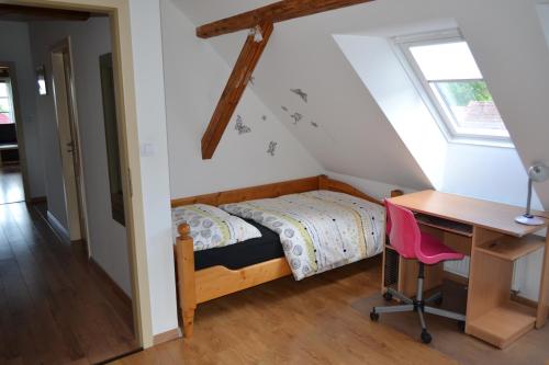 a small bedroom with a bed and a desk at Apartmány Nezdice na Šumavě in Nezdice