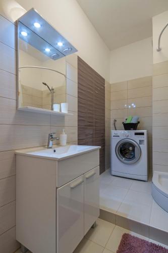 a bathroom with a sink and a washing machine at Apartment Danijela I in Pula