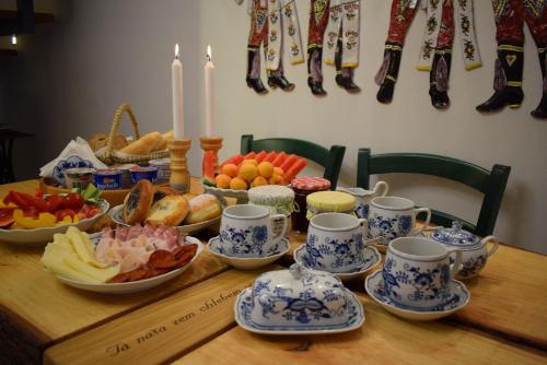 a wooden table with plates and cups and food on it at U Stařenky in Dolní Bojanovice