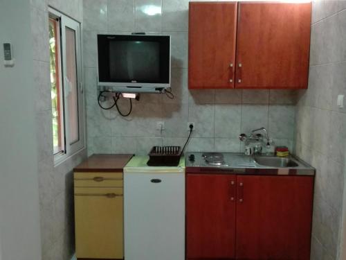a kitchen with a sink and a tv on the wall at Bar-Apartman 2 in Bar