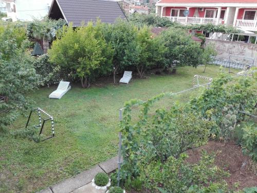a garden with two benches in the grass at Bar-Apartman 2 in Bar