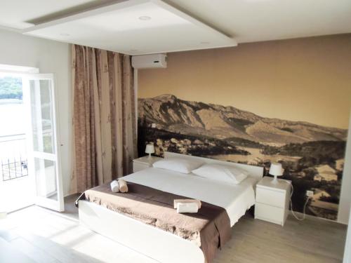 a bedroom with a bed with a painting on the wall at Villa Nobilo in Lumbarda
