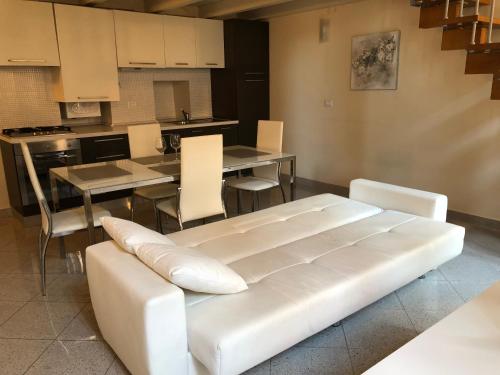 a living room with a white couch and a kitchen at ABCdecor Italia in Imperia