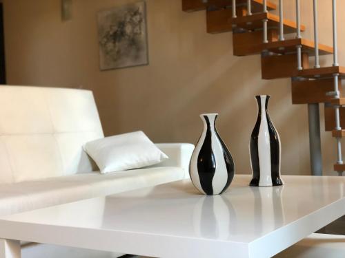 two black and white vases sitting on a white table at ABCdecor Italia in Imperia