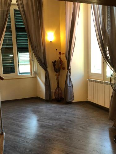 an empty room with curtains and a vase with flowers at ABCdecor Italia in Imperia