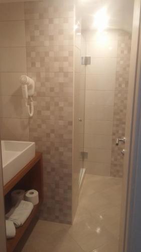 a bathroom with a shower with a glass door at Rooms Vukušić in Rab