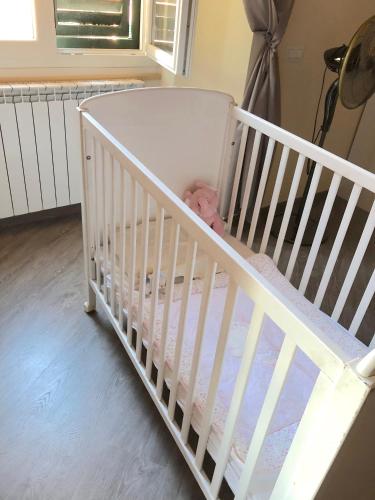 a white crib with a baby doll in it at ABCdecor Italia in Imperia