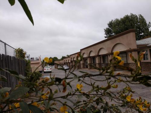 a row of buildings with cars parked in a parking lot at Bartlett Motel in Lomita