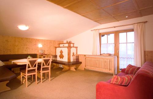 sala de estar con sofá, mesa y sillas en Gstreinhof, en Längenfeld