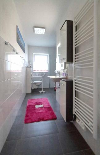 a bathroom with a sink and a red rug at Ferienhaus Annemiete in Putbus