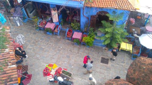 una vista in alto di un negozio con persone in piedi fuori di Hotel Al kassaba a Chefchaouen