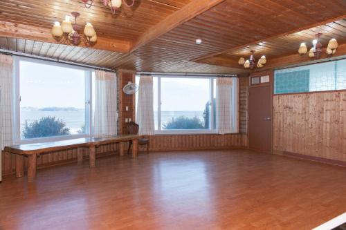 a large room with a wooden floor and large windows at Sunrise Pension in Hwaseong