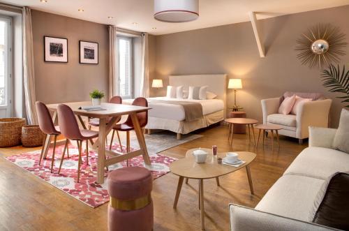 une chambre d'hôtel avec un lit, une table et des chaises dans l'établissement Appartements des Ducs, à Dijon