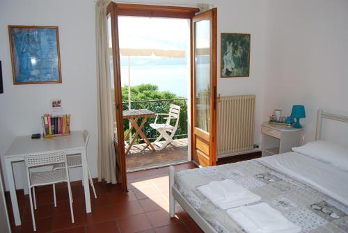 a bedroom with a bed and a table and a balcony at B&B Nonno Leo in Cannero Riviera