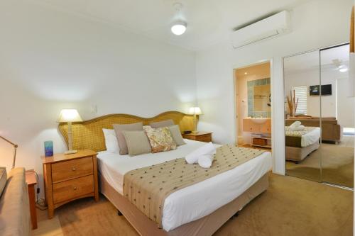 a bedroom with a large bed and a bathroom at Seascape Holidays at Portsea in Port Douglas