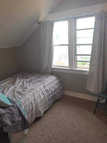 a small bedroom with a bed and a window at Duplex with a View in Drumheller