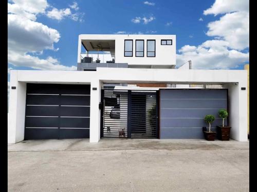 a house with two garage doors in front of it at Modern Apartment in Rosarito