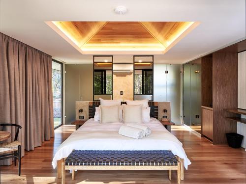 a bedroom with a large bed with a wooden ceiling at Amaroo Retreat & Spa in Mount Helena