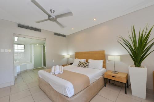 Schlafzimmer mit einem großen Bett und einem Deckenventilator in der Unterkunft Seascape Holidays at Club Tropical in Port Douglas