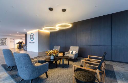 a lobby with chairs and tables and a wall at Boardwalk Burleigh Beach - Official in Gold Coast