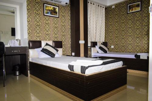 a bedroom with two beds in a room at Hotel Biswanath in Guwahati