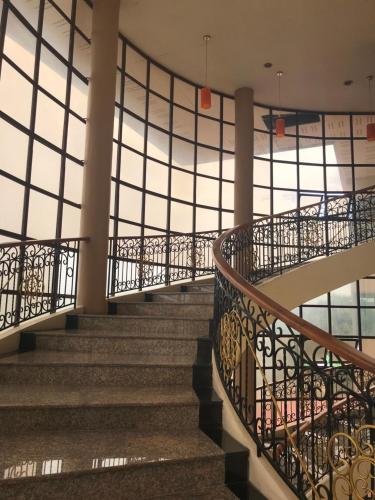 a spiral staircase in a building with windows at Butnamtong Hotel in Lampang