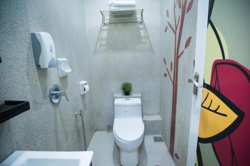 a bathroom with a toilet and a sink with a plant on it at DJ Citi Point Hotel in Kuala Terengganu