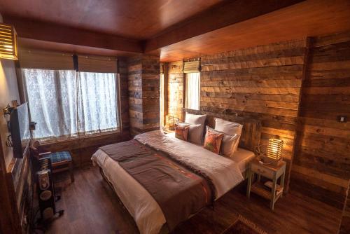 a bedroom with a bed and a wooden wall at Meena Bagh Shimla in Shimla