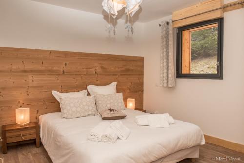 ein Schlafzimmer mit einem großen weißen Bett mit zwei Handtüchern darauf in der Unterkunft La Ferme du Nol in La Bresse