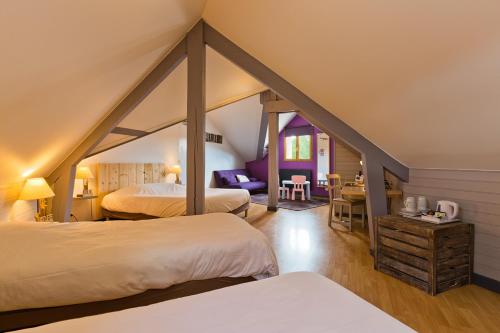 En eller flere senge i et værelse på Logis Hôtel Volcan Sancy
