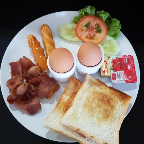 a plate of food with eggs bacon toast and other foods at AM Surin Place - SHA Extra Plus in Surin Beach