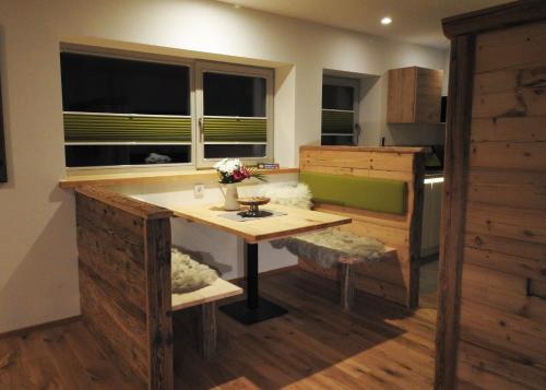 a room with a table and a bench and windows at Leos Alpenblume inklusive Sommer Bergbahnticket in Oberstdorf