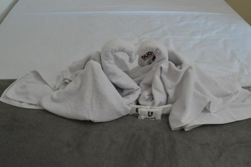 una pila de toallas en una cama en Pousada Ubarana, en Maragogi