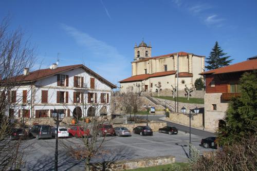 a parking lot with cars parked in front of a building at Zezilionea in Olaberría