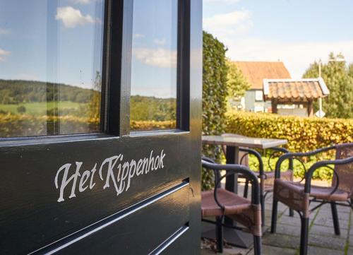 a restaurant with a table and chairs and a window at Hotel,Herberg & Appartementen de Smidse in Epen
