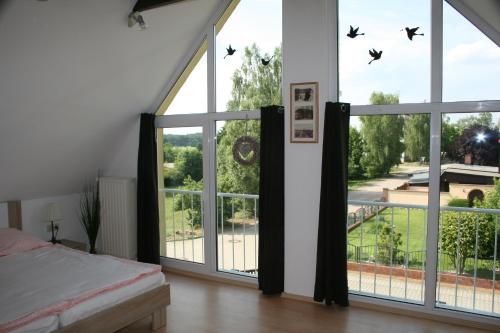 a bedroom with a bed and a large window at Ferienhaus Straupitz-Spreewald mit Sauna in Straupitz