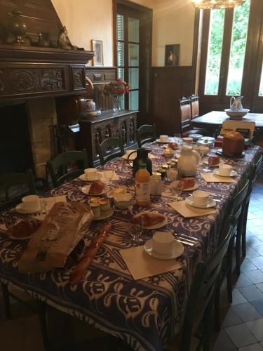 a long table with plates and utensils on it at Domaine du Valromey in Champagne-en-Valromey