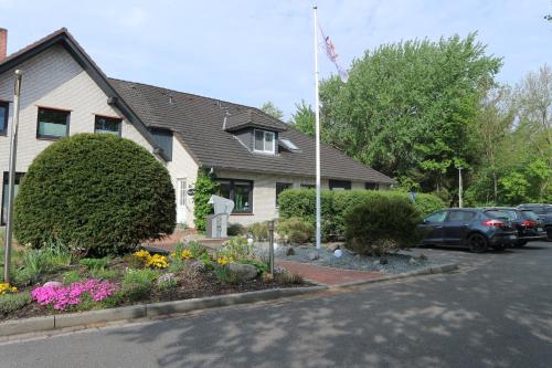 a house with cars parked in a parking lot at Hus op de Diek in Sankt Peter-Ording