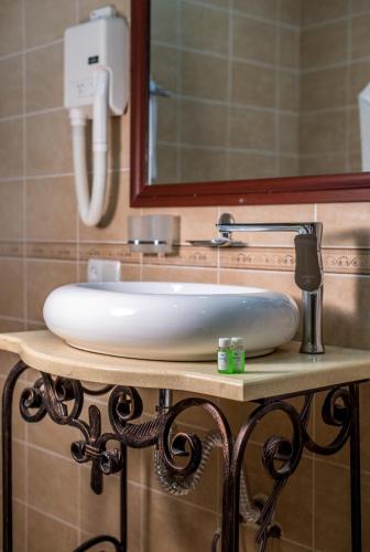 a white sink on a table in a bathroom at Orient Star Khiva Hotel- Madrasah Muhammad Aminkhan 1855 in Khiva