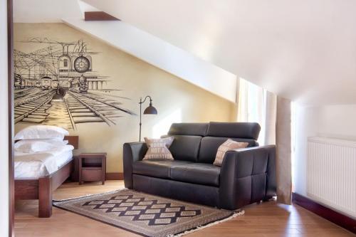 a living room with a couch and a clock on the wall at BoutiqueHotel Aristo in Białystok