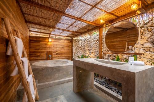a bathroom with two sinks and a large mirror at Green Escape Eco Resort in Uluwatu