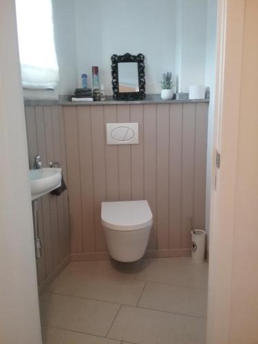 a bathroom with a white toilet and a sink at B&B 't Hemelbedje in Nieuwpoort